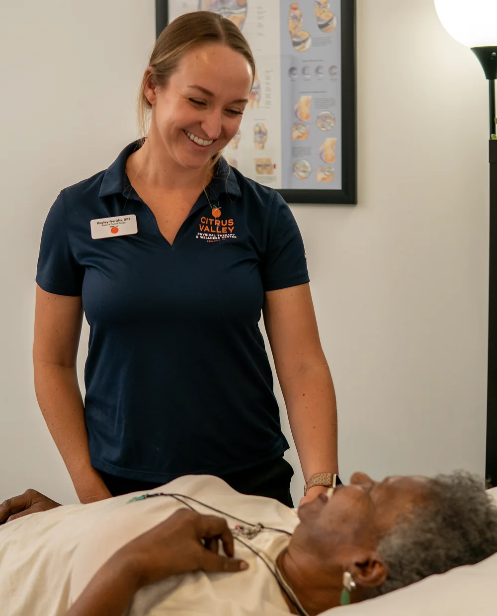 Smiling Citrus Valley physical therapist checking in with a patient on the treatment table